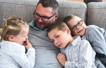 Delayed Fatherhood And Autism A young boy sitting on a couch