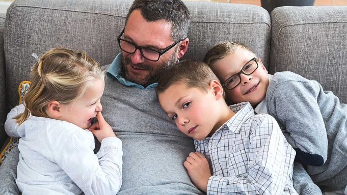 Delayed Fatherhood And Autism A young boy sitting on a couch