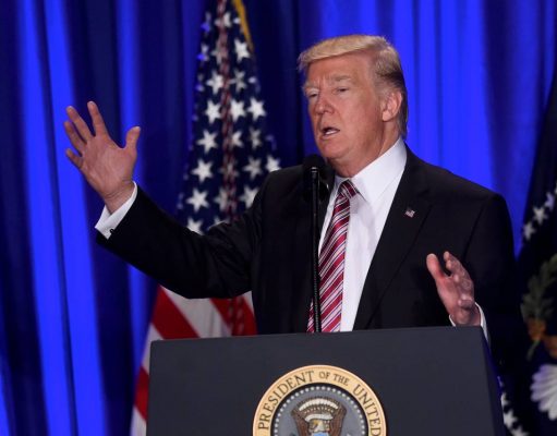 Donald J. Trump’s First 100 Days Donald Trump standing on a stage in front of a curtain