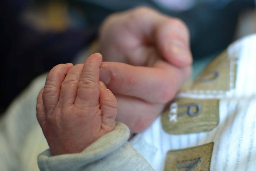 A hand holding a baby