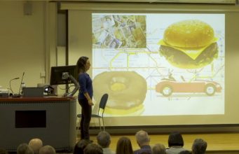 An Introduction To Evolutionary Psychology A group of people standing in front of a television